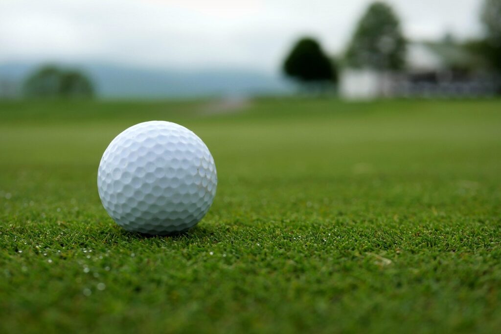 Golfpallo vihreällä nurmikolla golfkentällä.